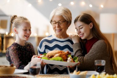 Şükran Günü, Sonbahar ziyafeti. Masada oturup bayramı kutlayan mutlu bir aile. Geleneksel yemek. Büyükanne ve torunlar..   