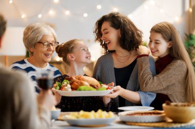 Şükran Günü, Sonbahar ziyafeti. Masada oturup bayramı kutlayan mutlu bir aile. Geleneksel yemek. Büyükanne ve torunlar..   