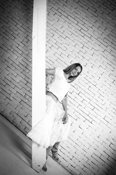 女孩在楼梯上与砖墙和白色 — 图库照片