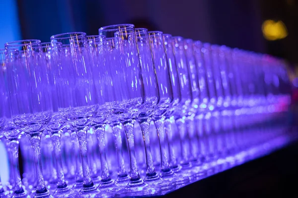 Copa de champán en la mesa, luces de color azul Imagen de stock