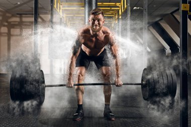 Deadlift. Bir kas adam egzersiz halter vasıl jimnastik salonu ile portresi