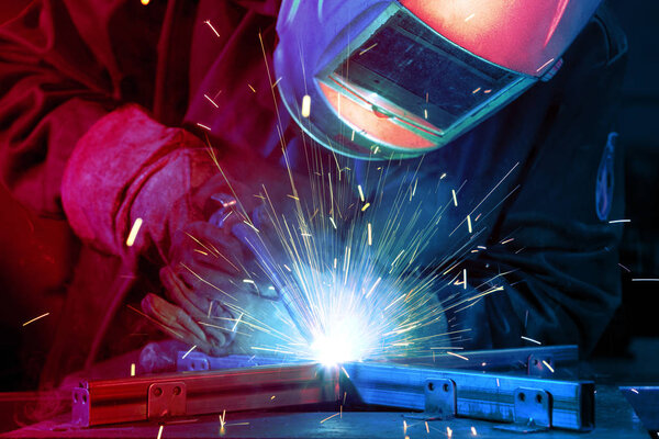 Welder erecting technical steel. Industrial steel welder in factory technical