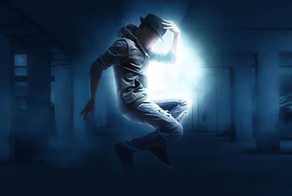 Man break dancing on dark light background