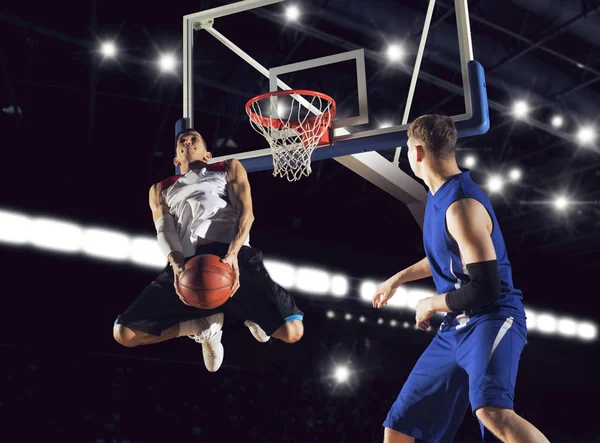 Two basketball players in action in gym