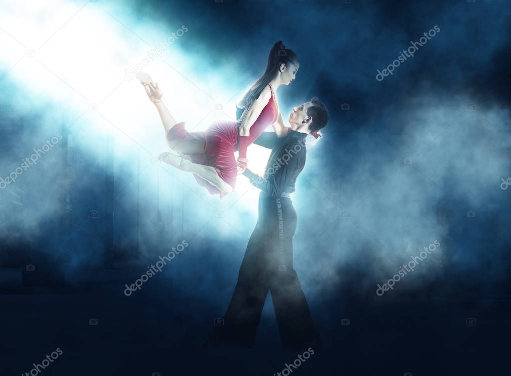 Pair of dancers dancing ballroom smoke background