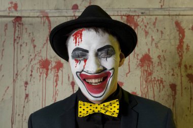 Korkunç şeytani palyaço duvar arka plan üzerinde bir melon şapka