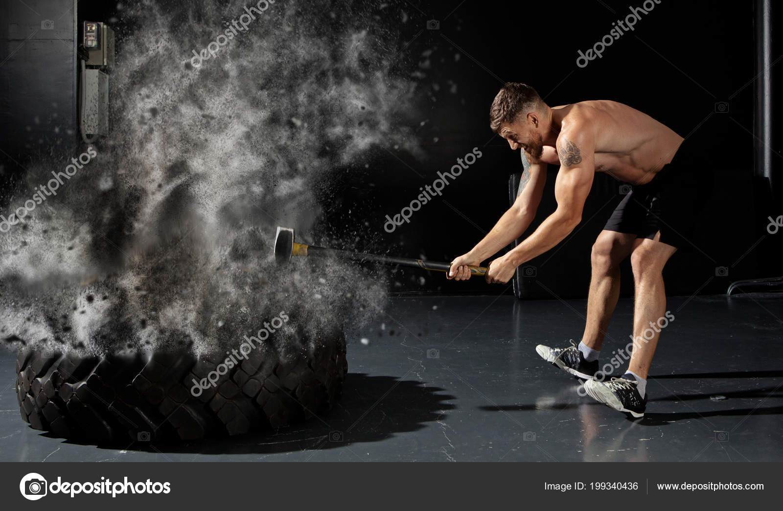 Muscular Man Hitting Wheel Tire Hammer Sledge Stock Photo by ©andreyuu