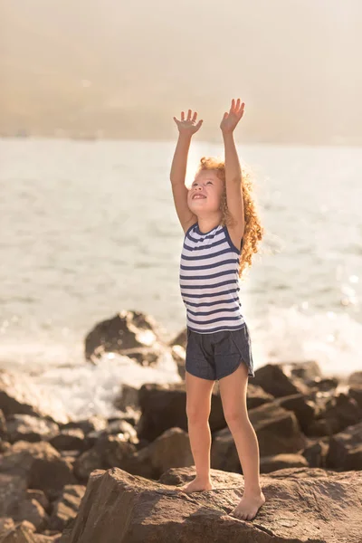 Bir Deniz Kenarında Bir Kayanın Üzerine Kaldırdı Elleriyle Küçük Kızla — Stok fotoğraf