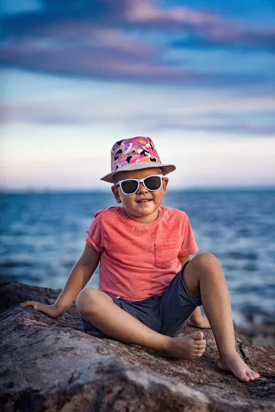 Pequeno Menino Sorrindo Está Sentado Rocha Perto Mar — Fotografia de Stock