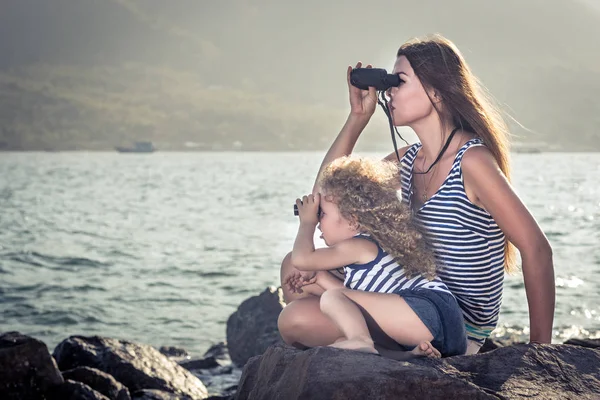 Bambina Madre Guardando Lontano Con Binocolo Seduta Una Roccia Vicino — Foto Stock