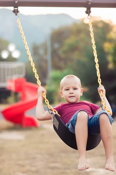 Menino balançando em um balanço — Fotografia de Stock