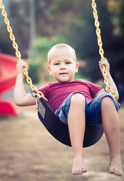 Little boy swinging on a swing — Stock Photo, Image