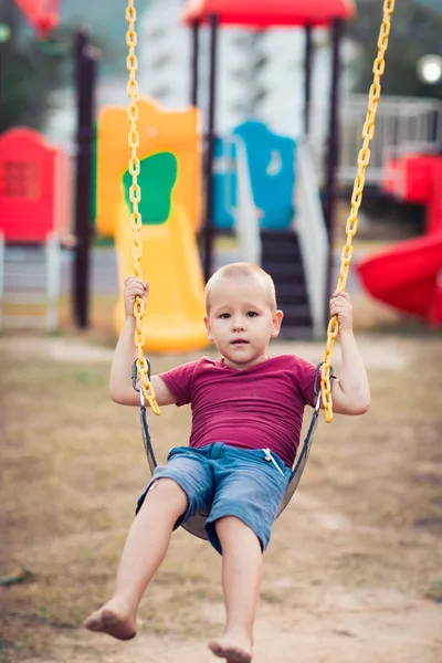 Petit garçon balançant sur une balançoire — Photo
