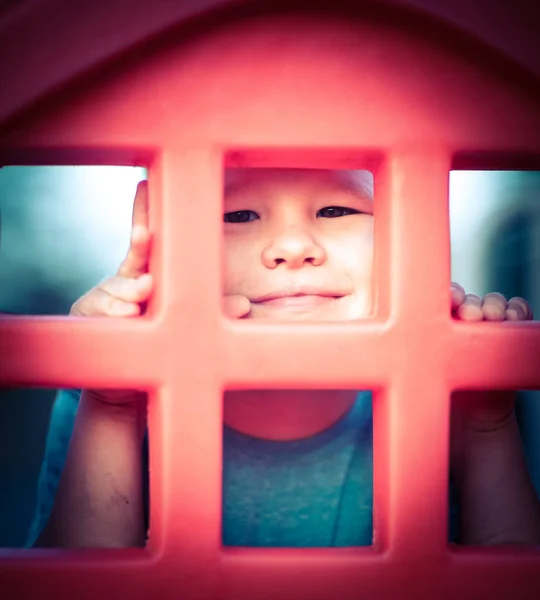 Piccolo ragazzo sorridente su uno scivolo — Foto Stock