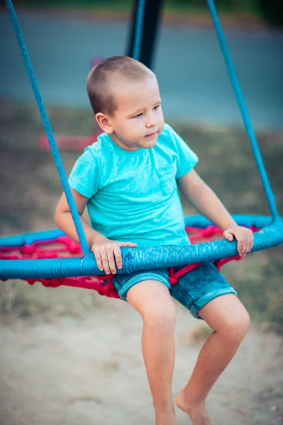 Menino balançando em um balanço — Fotografia de Stock