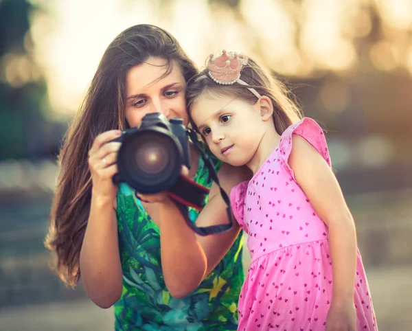 Mãe e filha tirando fotos com câmera — Fotografia de Stock