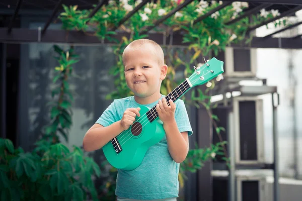 Portret van een schattige jongen met ukulele — Stockfoto