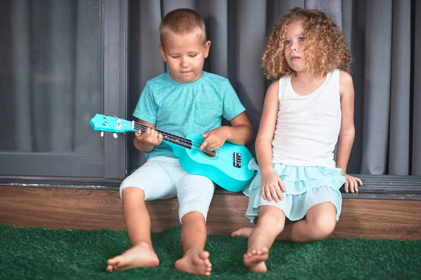 Portrét roztomilým dětem s ukulele — Stock fotografie