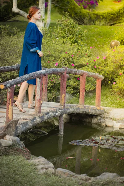 Vakker kvinne på en bro i parken – stockfoto