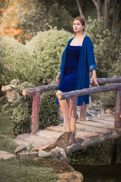 Hermosa mujer en un puente en el parque — Foto de Stock