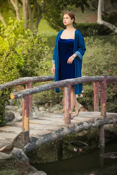 Mooie vrouw op een brug in het Park — Stockfoto