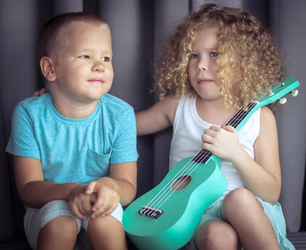 Portrét roztomilým dětem s ukulele — Stock fotografie