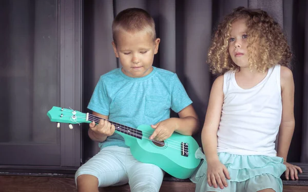 Portrét roztomilým dětem s ukulele — Stock fotografie