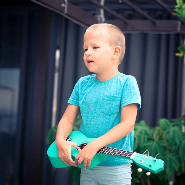 Портрет милого мальчика с укулеле — стоковое фото