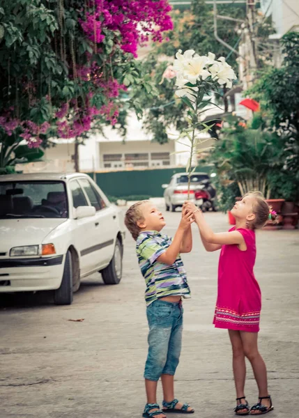 子供たちが花と一緒に通りを歩く — ストック写真