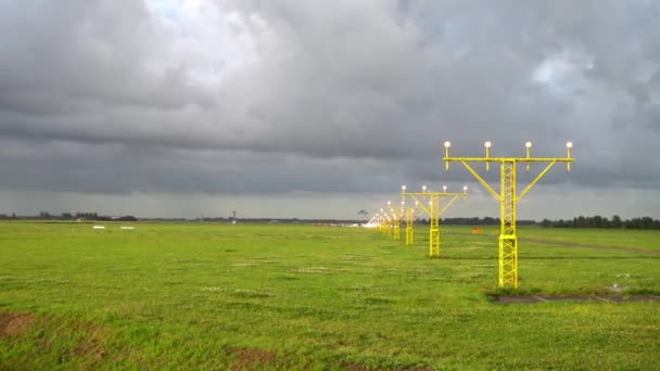 Самолёт приземляется на освещенной взлетно-посадочной полосе — стоковое видео