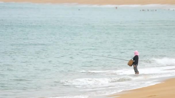 Uma mulher pega um peixe na fiação — Vídeo de Stock