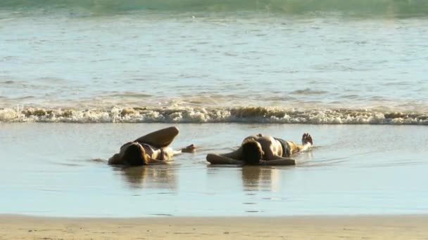 浜辺の砂の上に横たわる若いカップル — ストック動画