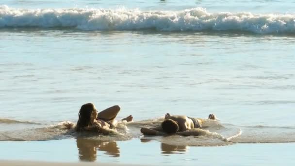 Młoda para leżące na piasku na plaży — Wideo stockowe