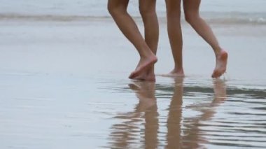 Karon beach, Phuket ıslak kum üzerinde çıplak ayakla yürümek çift