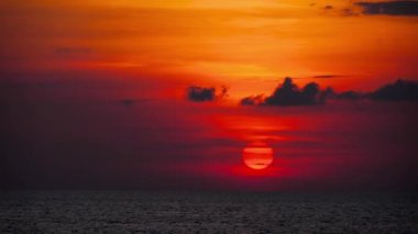 Okyanusun üzerinde kızıl gün batımı