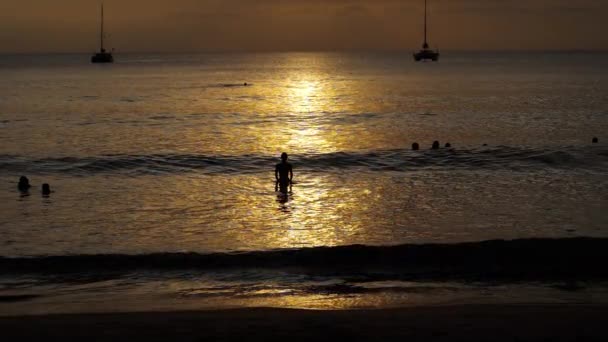 Прекрасний захід сонця з силуетами людей насолоджується океаном . — стокове відео