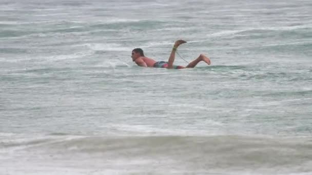 Surfista nas ondas na chuva de havy — Vídeo de Stock