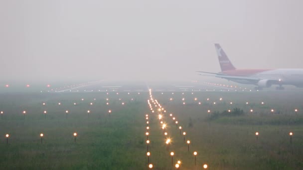 Самолет разворачивается на взлетно-посадочной полосе в густом тумане — стоковое видео