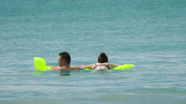 Couple on inflatable matress in ocean — Stock Video