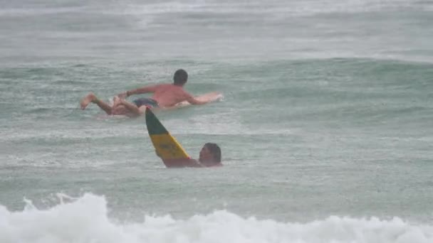 Surfare på vågorna vid havy regn — Stockvideo