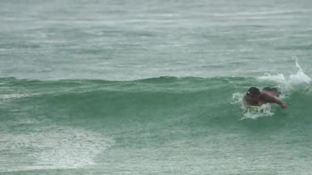 Surfista en las olas bajo la lluvia. — Vídeo de stock