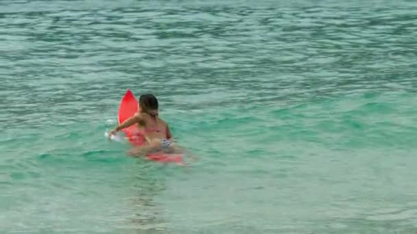 Aantrekkelijke surfer vrouw op een surfplank zweven in de Oceaan — Stockvideo