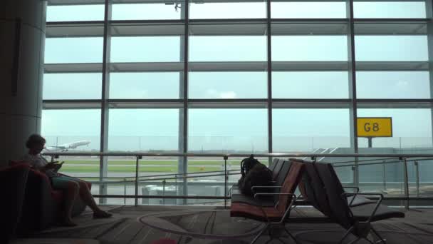 Kadın kapı uçuş kalkış için terminal koltukta bekliyor — Stok video