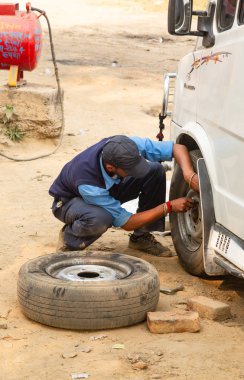 Bir adam bir tekerlek arabada giderir.