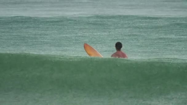 Surfer na fale w havy rain — Wideo stockowe