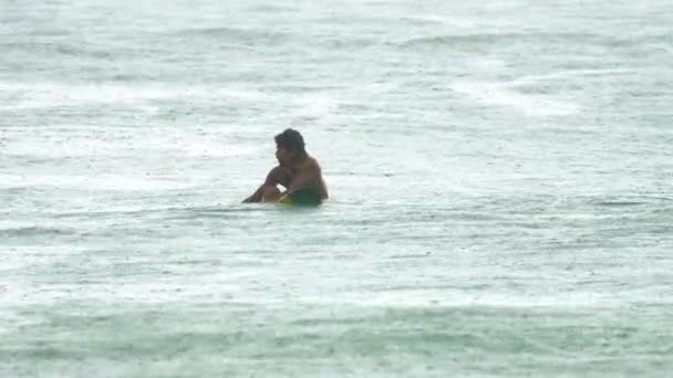 Surfer på bølgerne på havy regn – Stock-video