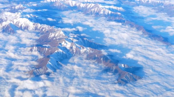 Прекрасний вид через вікно літака, літак, що летить над горами з хмарами — стокове відео