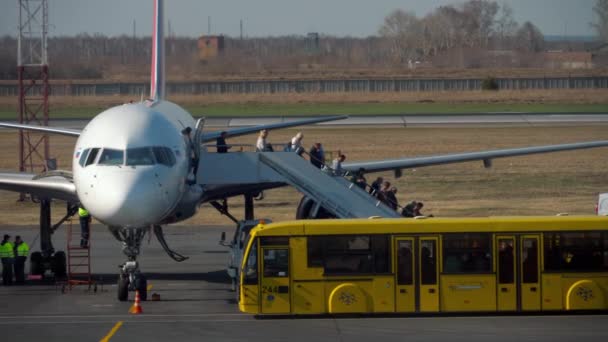 Пассажиры покидают самолет — стоковое видео