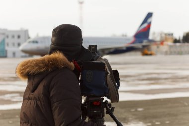 Kameraman uçaktan iner.