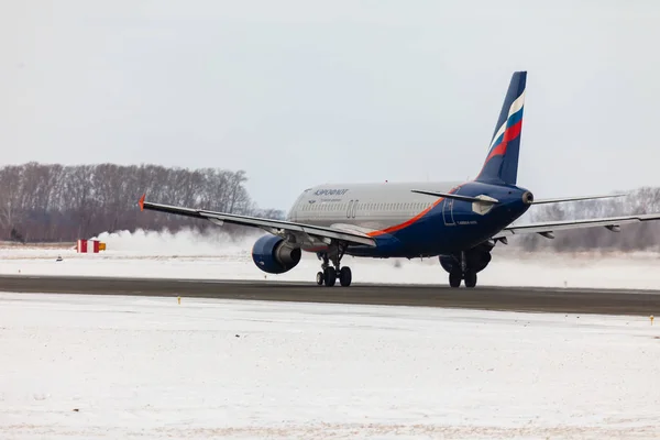 The plane accelerates on the winter runway — Stock Photo, Image